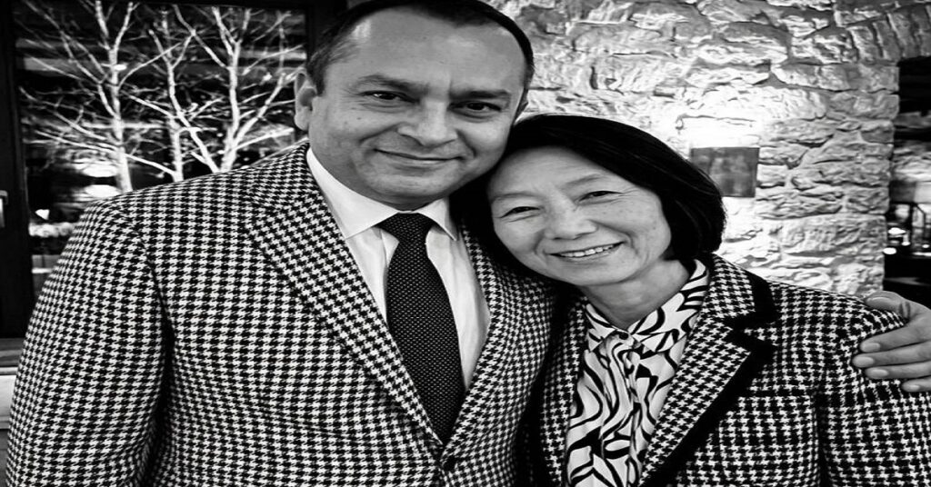 Keiko Fujimoto and Sunny Balwani posing together in matching houndstooth blazers, smiling in a black and white photo.